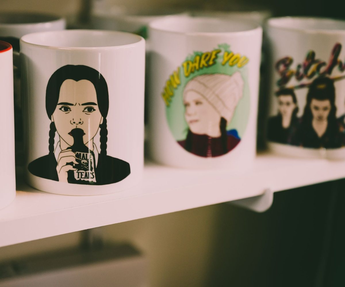 Printed ceramic mugs lined up on a shelf — every design is printed to order